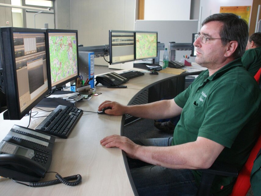 Menschen an Bildschirmen überwachen den Wald